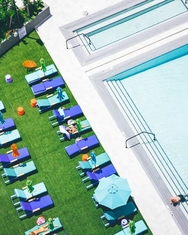 Piscine de style resort avec spa, chaises longues et bâtiments résidentiels modernes entourés de pins